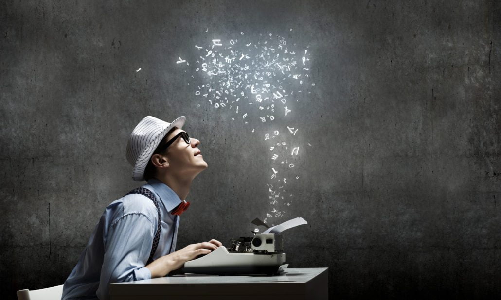 A freelance copywriter at his desk with sparkles coming from his typewriter.