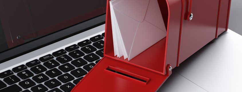Writing email. Laptop computer and letterbox on top, highlighting email writing.